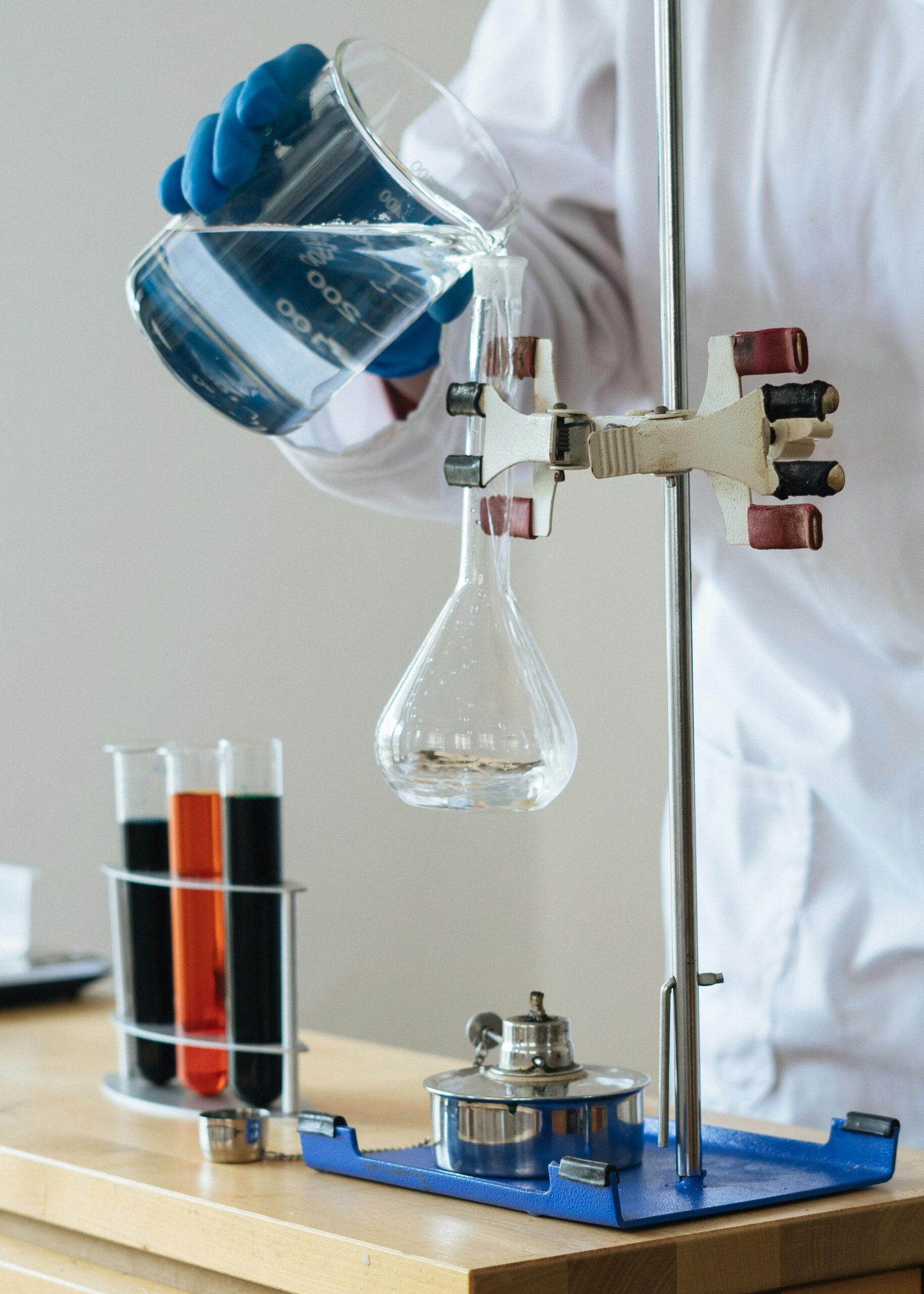 About Scientist pouring liquid into a flask in a laboratory setting for research.